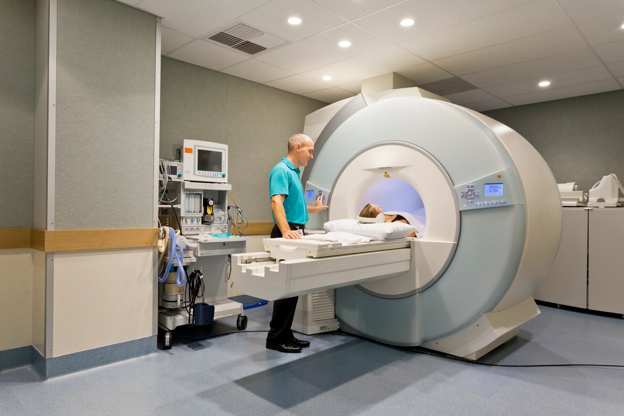 Technician preparing an MRI machine in a medical facility.