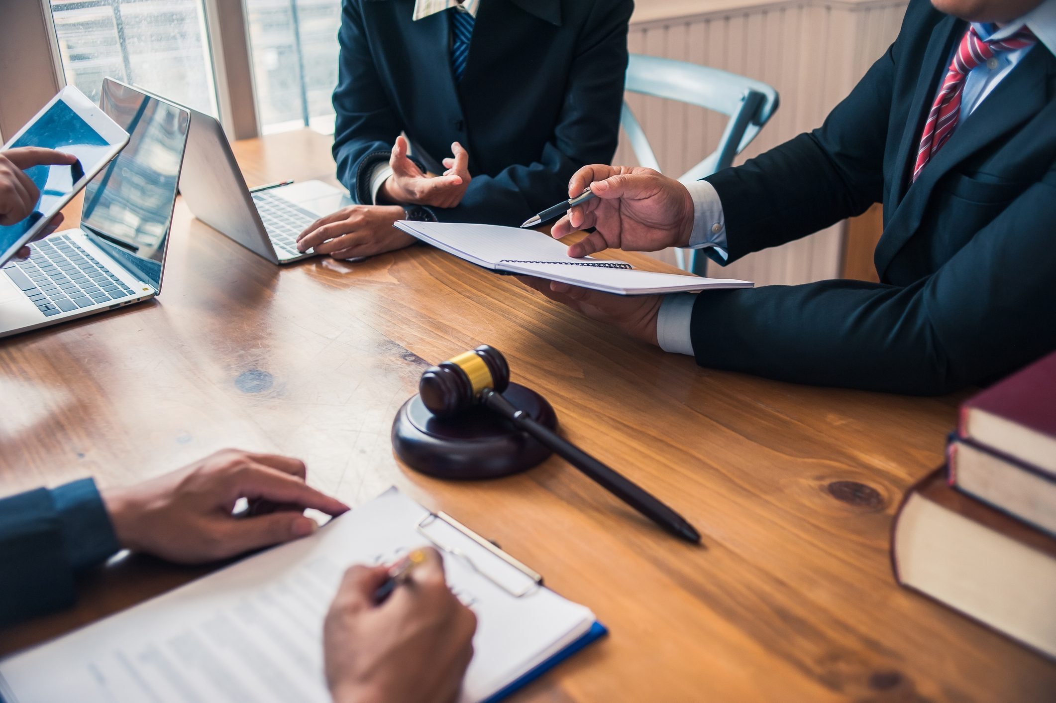 Legal professionals discussing documents with a gavel on the table.