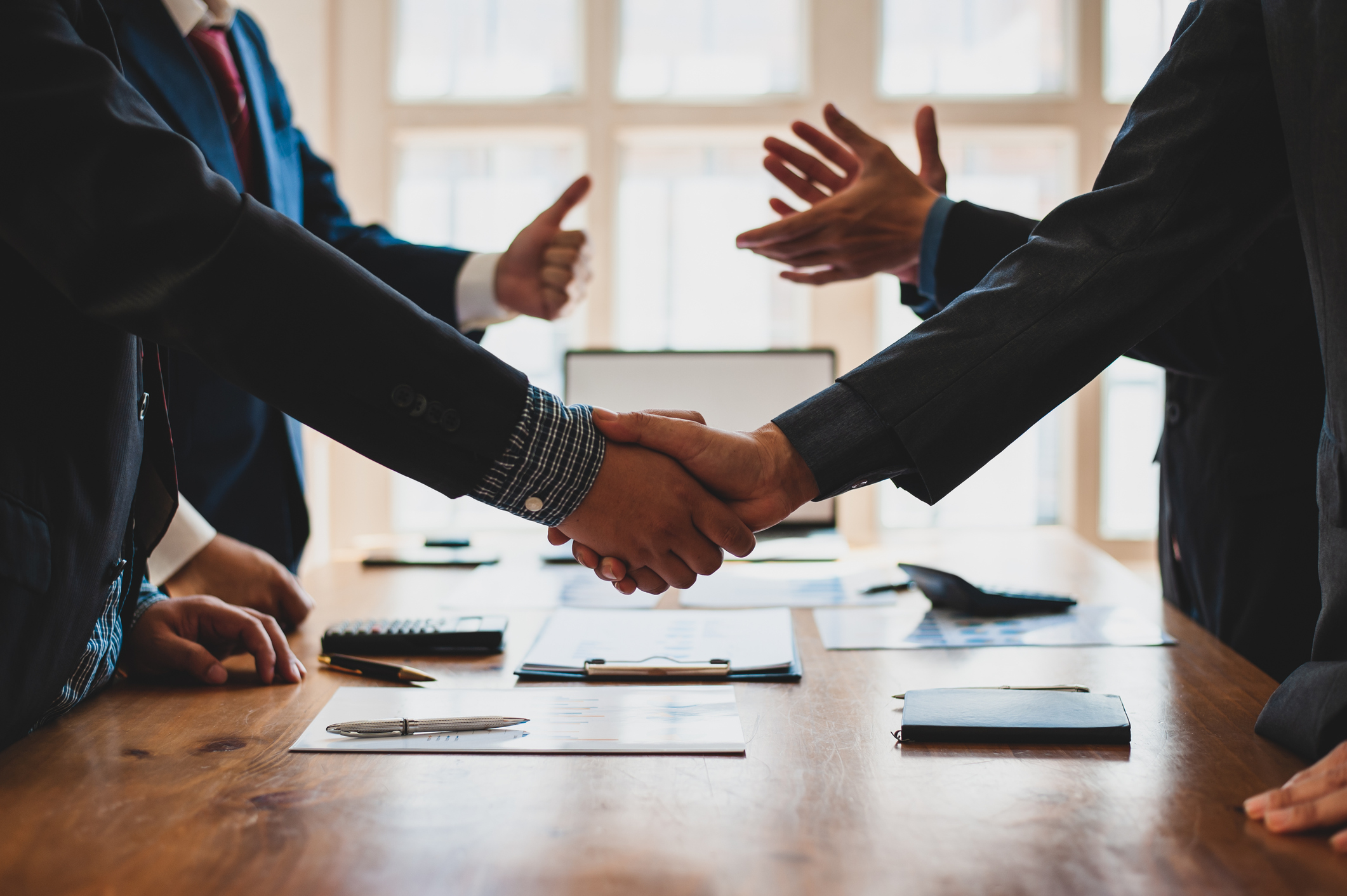 Business handshake sealing a deal in a professional setting.