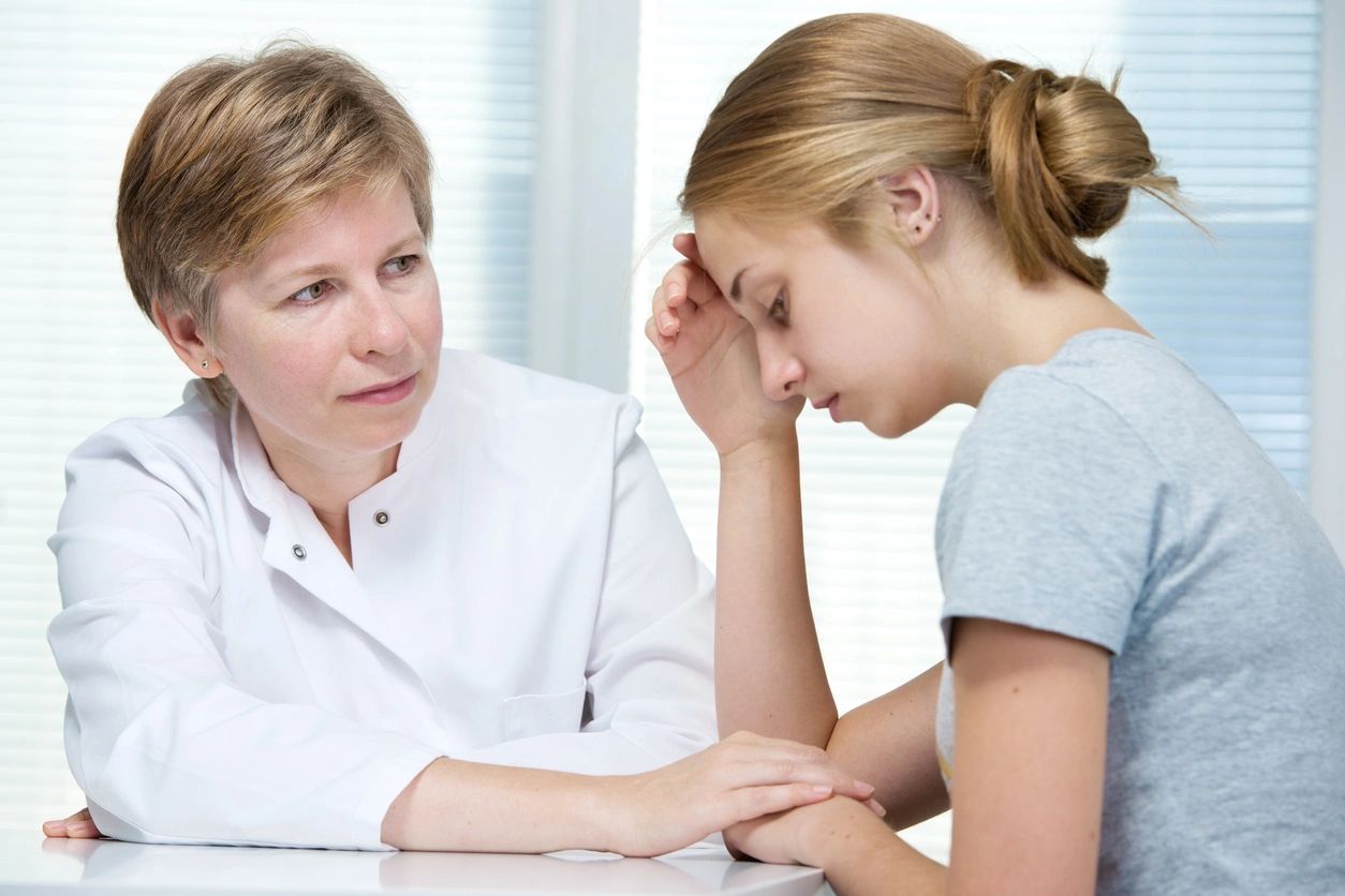 A doctor comforting a distressed woman during a consultation.
