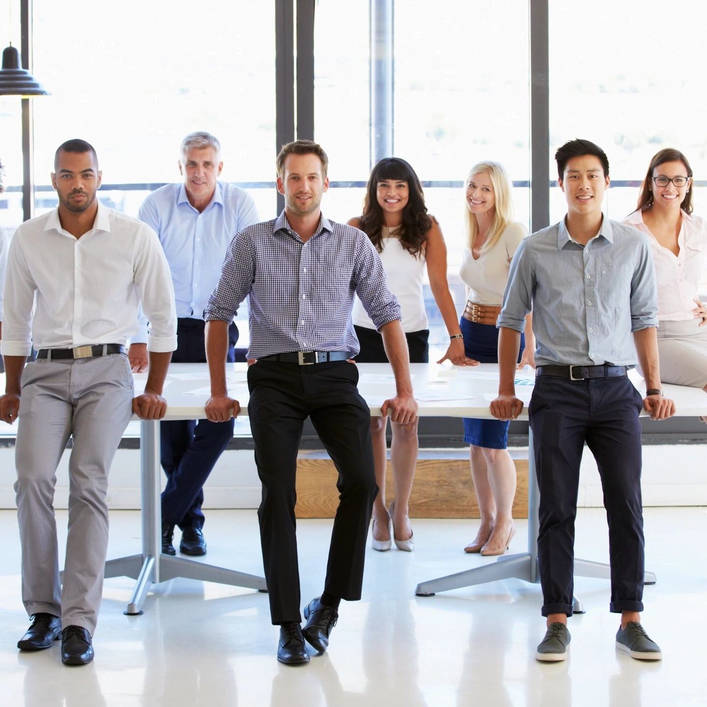 A diverse business team posing confidently in a modern office space.