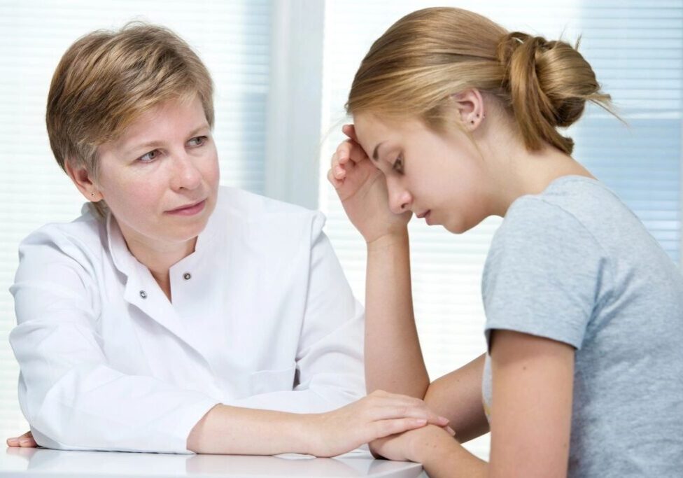 A doctor comforting a distressed woman during a consultation.